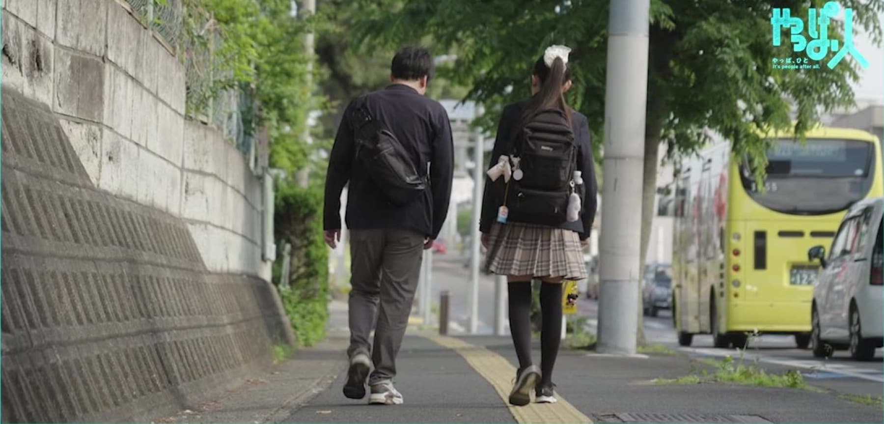 点字ブロックのある歩道を並んで歩く、鈴木さんと歩行訓練士の髙田さん